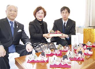 石澤桂司区長に人形を手渡す河野さん（中央）左は鷺沼町会持田和夫会長