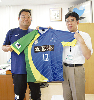 川崎チームの春田さん（左）は９月、結成を石澤桂司区長に報告。ユニフォームを渡した