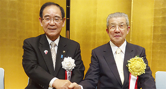 式典で阿部市長と握手を交わす都倉正明さん