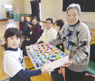 児童に記念品を贈呈する和田さん（右）