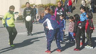 子どもたちに見本を見せる田中選手（左）