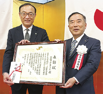 山田会頭（右）と表彰を受けた川崎フロンターレ藁科社長