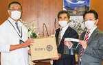 大坪病院長（左）に物品を手渡す吉崎前会長（中）と石崎前幹事