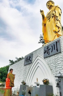 輝きを増した大仏像に手を合わせる僧侶