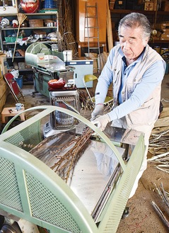 機械で「枝折り」の作業をする吉田さん