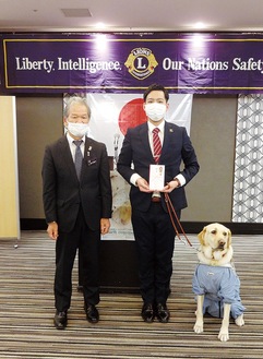 目代会長（左）から金一封を贈呈された池田さんと盲導犬クラール
