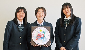(右から)芳賀さん、立体のロゴを持つ高原さん、佐田久さん