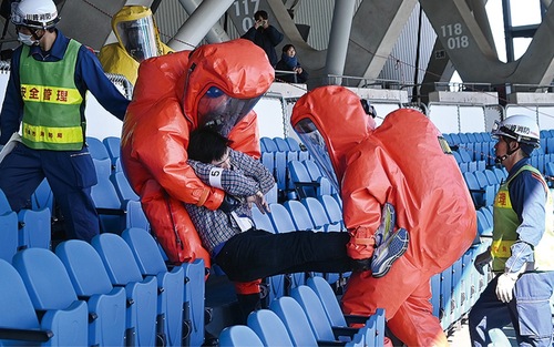 防護服を着て搬送する消防署員