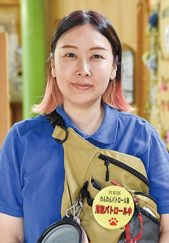 バッグに黄色いバッジを付けた山田さん