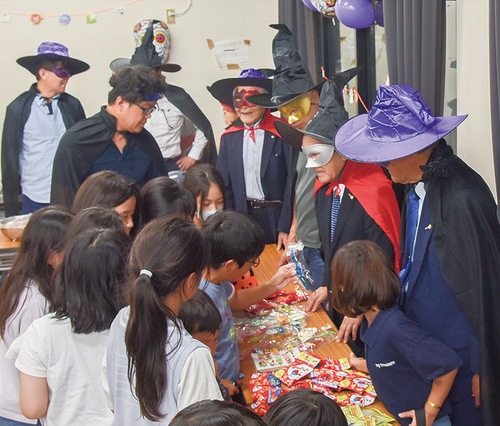 扮装した会員がお菓子を配った