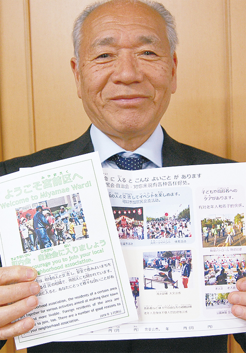 完成したリーフレットを手にする持田会長