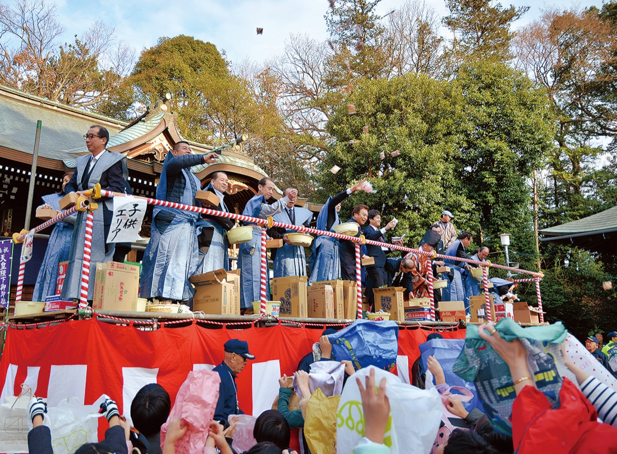 宙に舞う福豆に手を伸ばす参拝者ら=馬絹神社