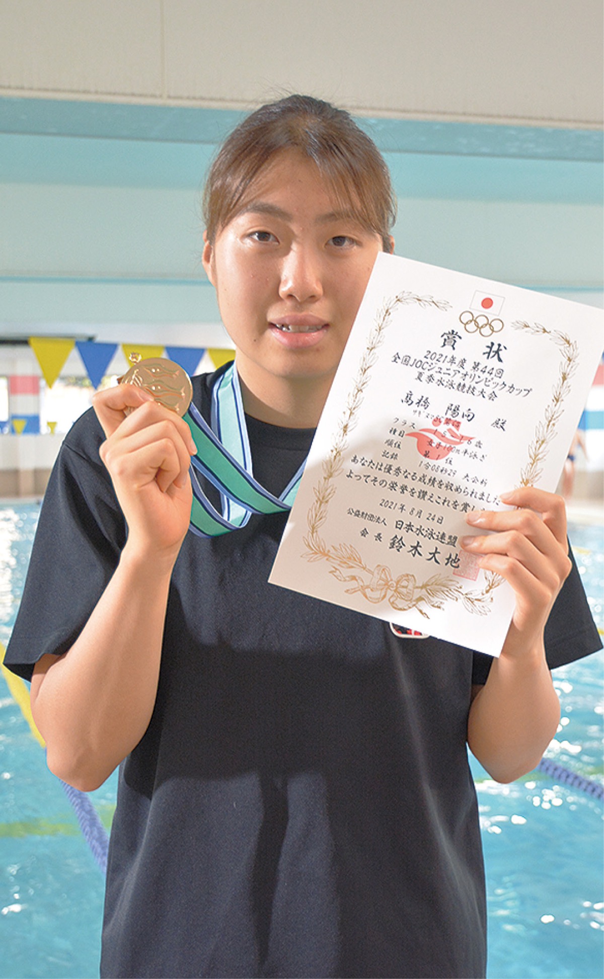 金メダルと賞状を掲げる高橋さん