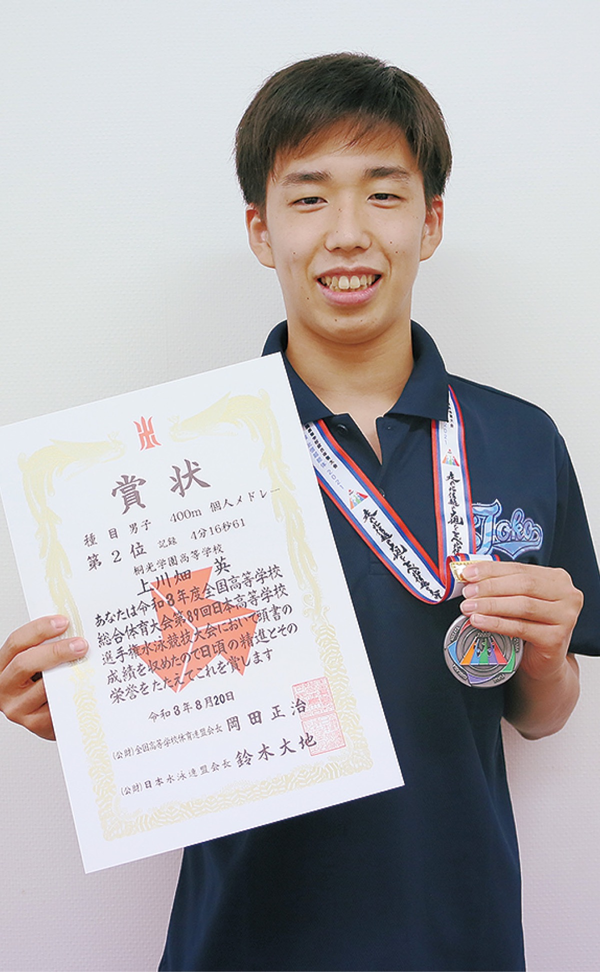 銀メダルと賞状を手に喜ぶ上川畑さん