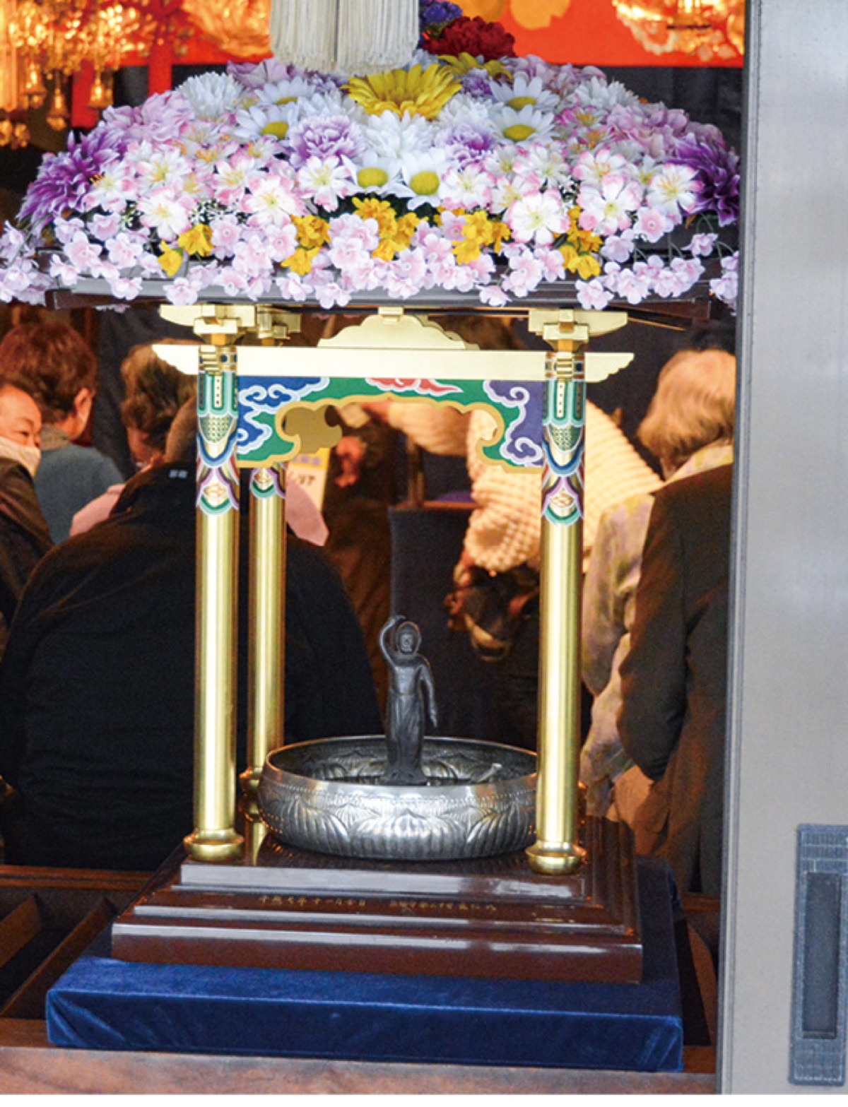 花で飾られた釈迦像に甘茶