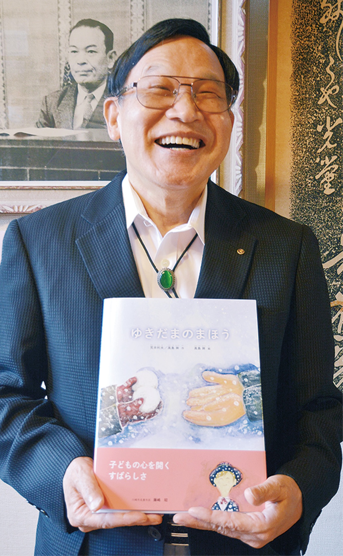 絵本を手に笑顔の荒井園長