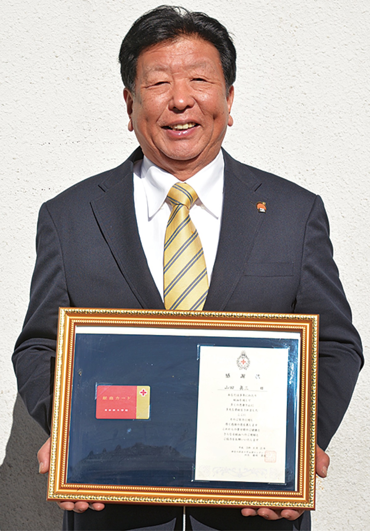 献血50回の感謝状を手にする山田さん