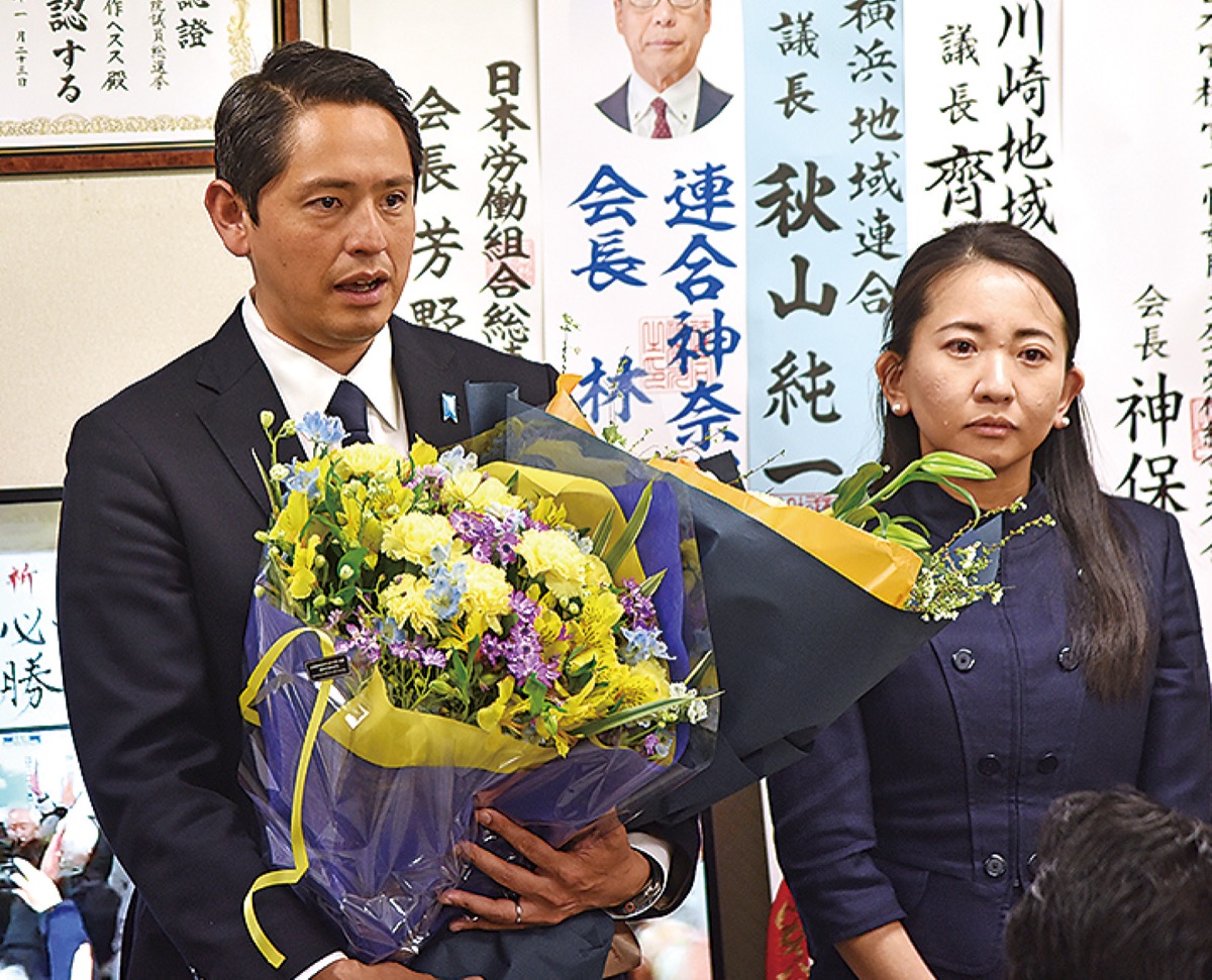 花束を受け取り支援者にあいさつをする深作氏（左）