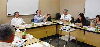 検討委で他都市の取組例を挙げる中村委員長（中央左）