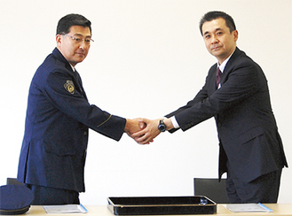 握手を交わす鳴海署長（左）と古川取締役