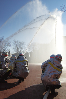 雲ひとつない新春の空に消防団員が一斉に放水。見事な演技に、来場者から喝采が上がった
