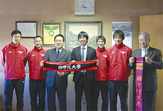 船橋区長（左から３人目）と記念撮影する前田監督（中央）と選手たち