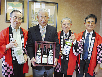 区長（右から３人目）に「たかつ」を手渡した、右から森さん、小坂さん、大竹さん