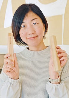 イベントでも使用する、国産木材で作られた楽器「クラベス」を手にする平松さん