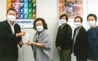 寄付金を手渡す紫村さん(左から２人目)