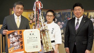 トロフィーを持つ本田選手（中央）と福田市長（右）、古賀支部長