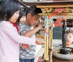 釈迦像に甘茶をかける子どもたち＝過去の様子