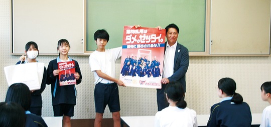 小山会長から啓発物を受け取る生徒たち