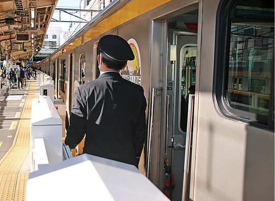 ホームドア内側の「発車メロディ放送ボタン」を操作する車掌