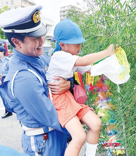笹に飾りをつける園児と警察官
