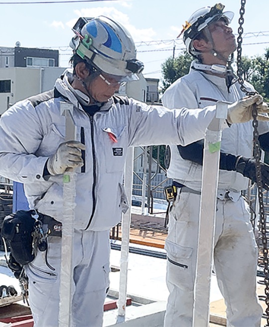 首元にウェアコンをつけながら作業するスタッフ