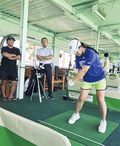 父・尚明さん（左）と川邉代表が見守る中アイアンショットを練習する戸張選手