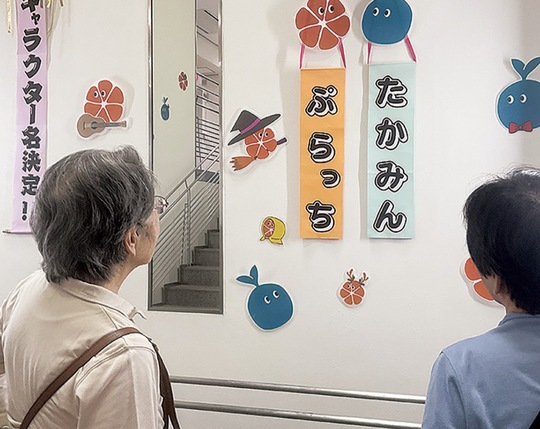 マスコットの愛称に注目するイベント来場者