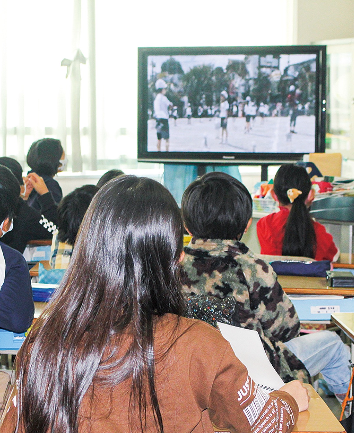 他の学年の競技の様子をリモートで視聴しながら応援する児童たち