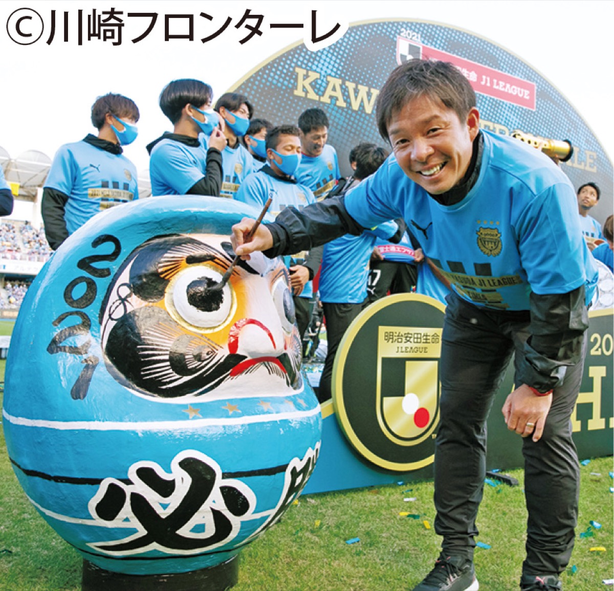 必勝だるまに目入れする鬼木監督