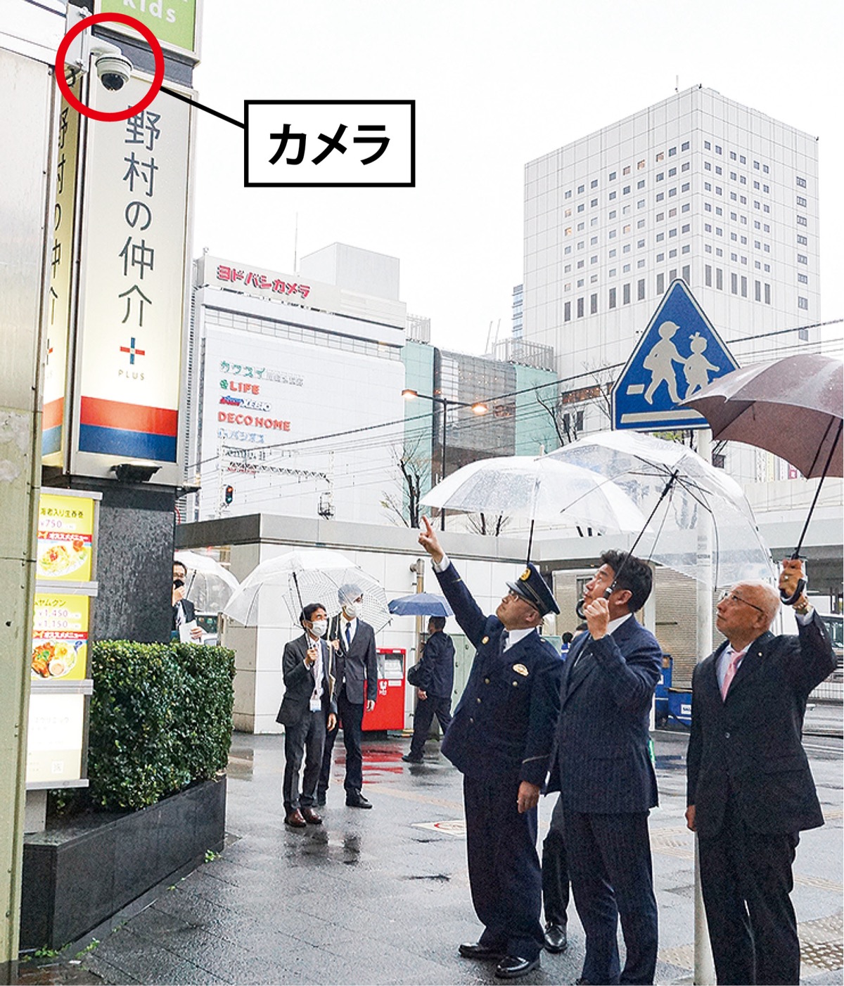防犯カメラを見上げる関係者