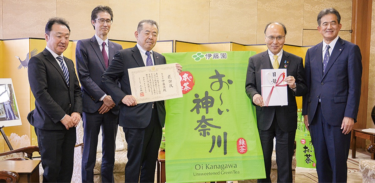 感謝状を手にする本庄周介代表取締役副社長執行役員と目録を手にする平田良徳副知事