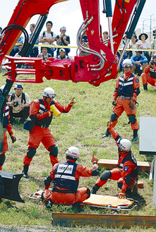 市民が見守る中、双腕作業機による緊迫する救出訓練が行われた