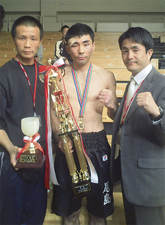 尾島選手（中央）と新田会長（右）、孫チーフトレーナー（左）