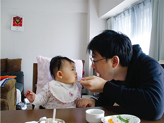 （右）吉田さんの作品。赤ちゃんが父の顔をじっと見つめる