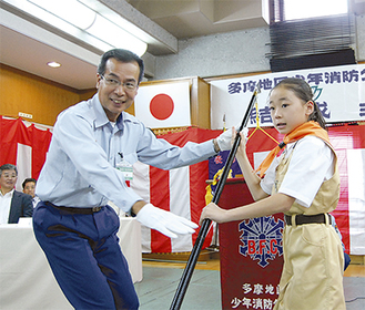 石井署長からクラブ旗を受け取るリーダーの田村さん