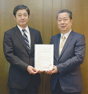 川崎市との協定書を持つ鳥海理事長と田商事の鈴木武龍専務取締役（左）