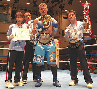 ２冠を奪取した西田選手と新田渉世会長（右）