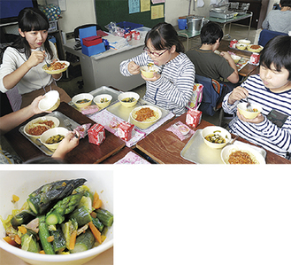 献立の一つ、地元産アスパラガス入りの野菜のソテー（下）。児童と給食を食べる加藤さん（左）