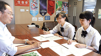 区長室でインタビューする上岡さん（右）、中村さん