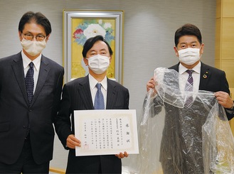 (左から)斎藤取締役、杉山社長、ポンチョを持つ福田市長